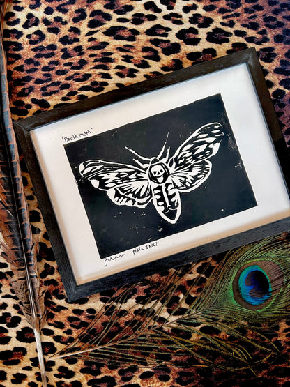 Moth Lino print in a frame, leopard print background with peacock feathers 